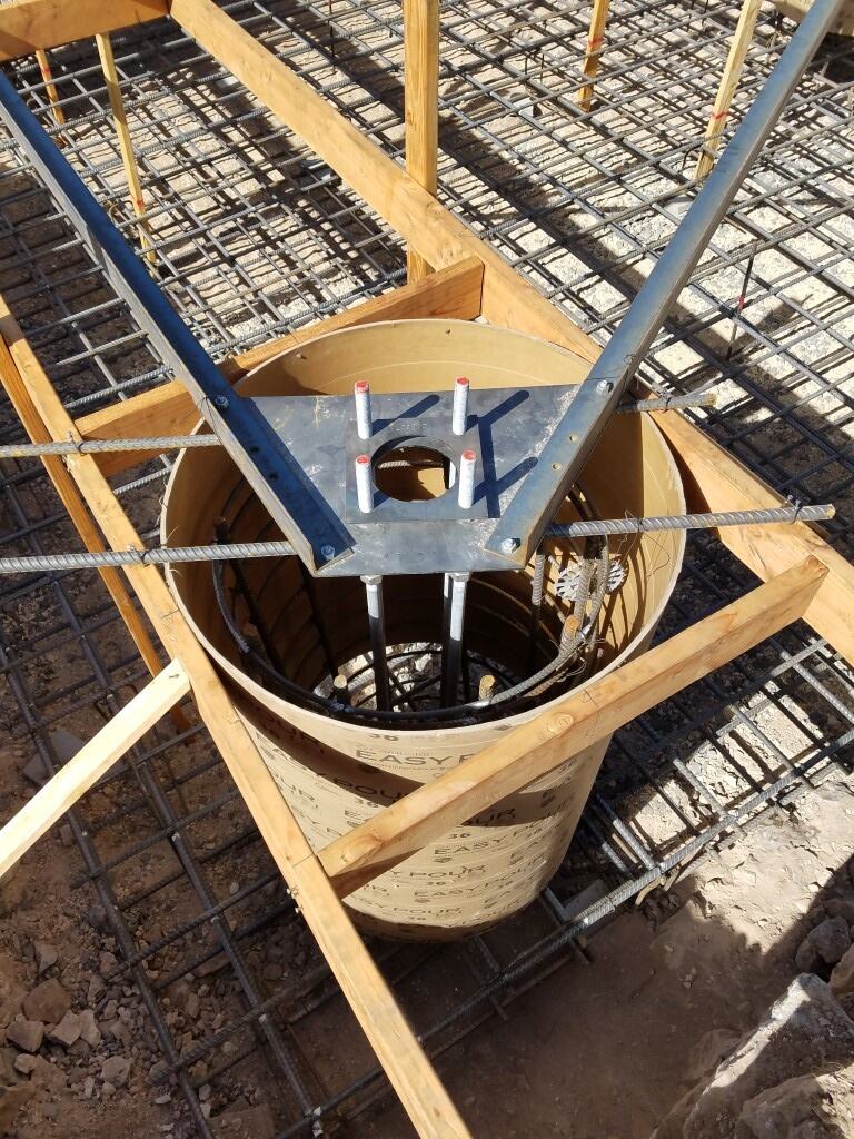 Anchor bolts and base plate set in a tower foundation pier