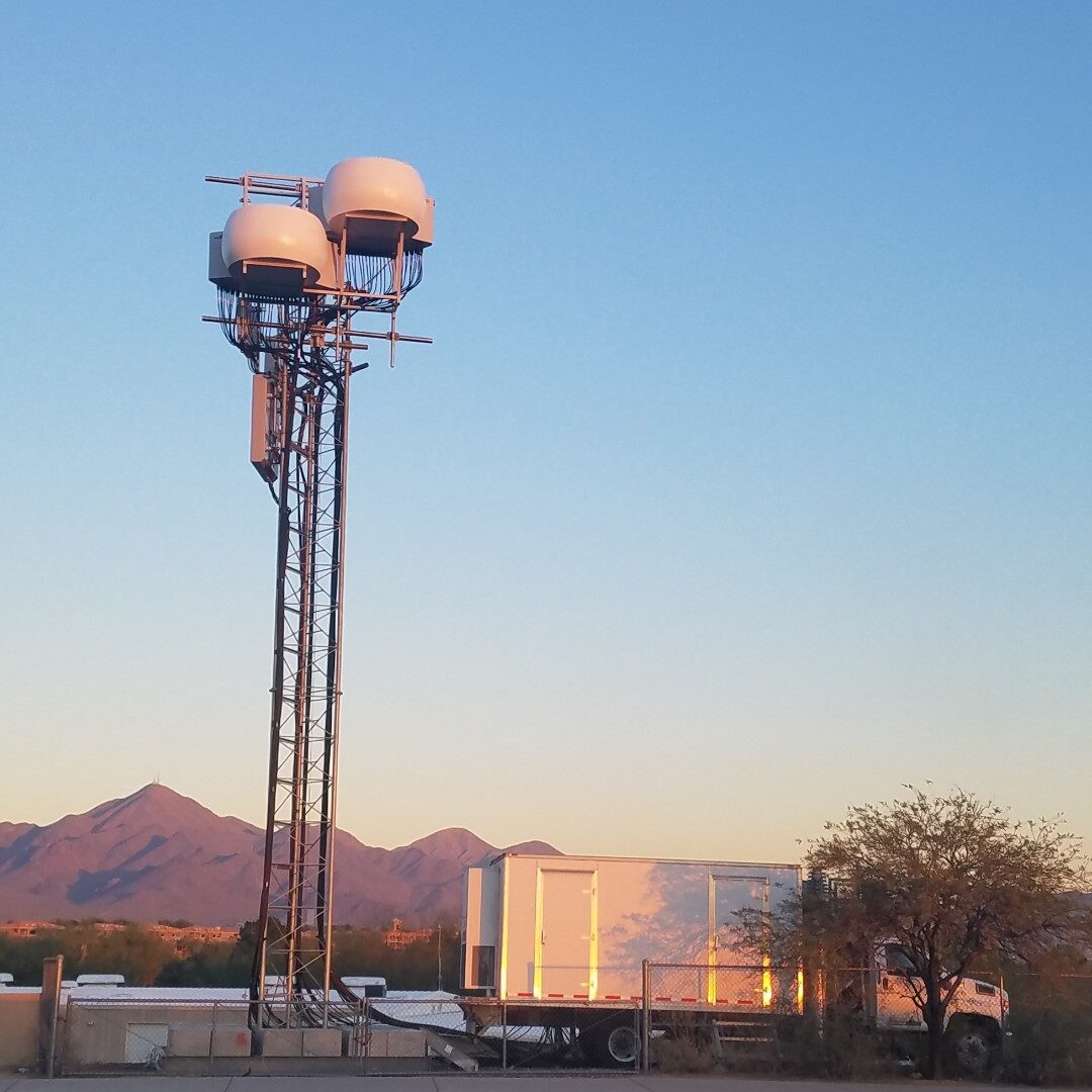 Temporary COW lattice mast with dual radomes and equipment shelter