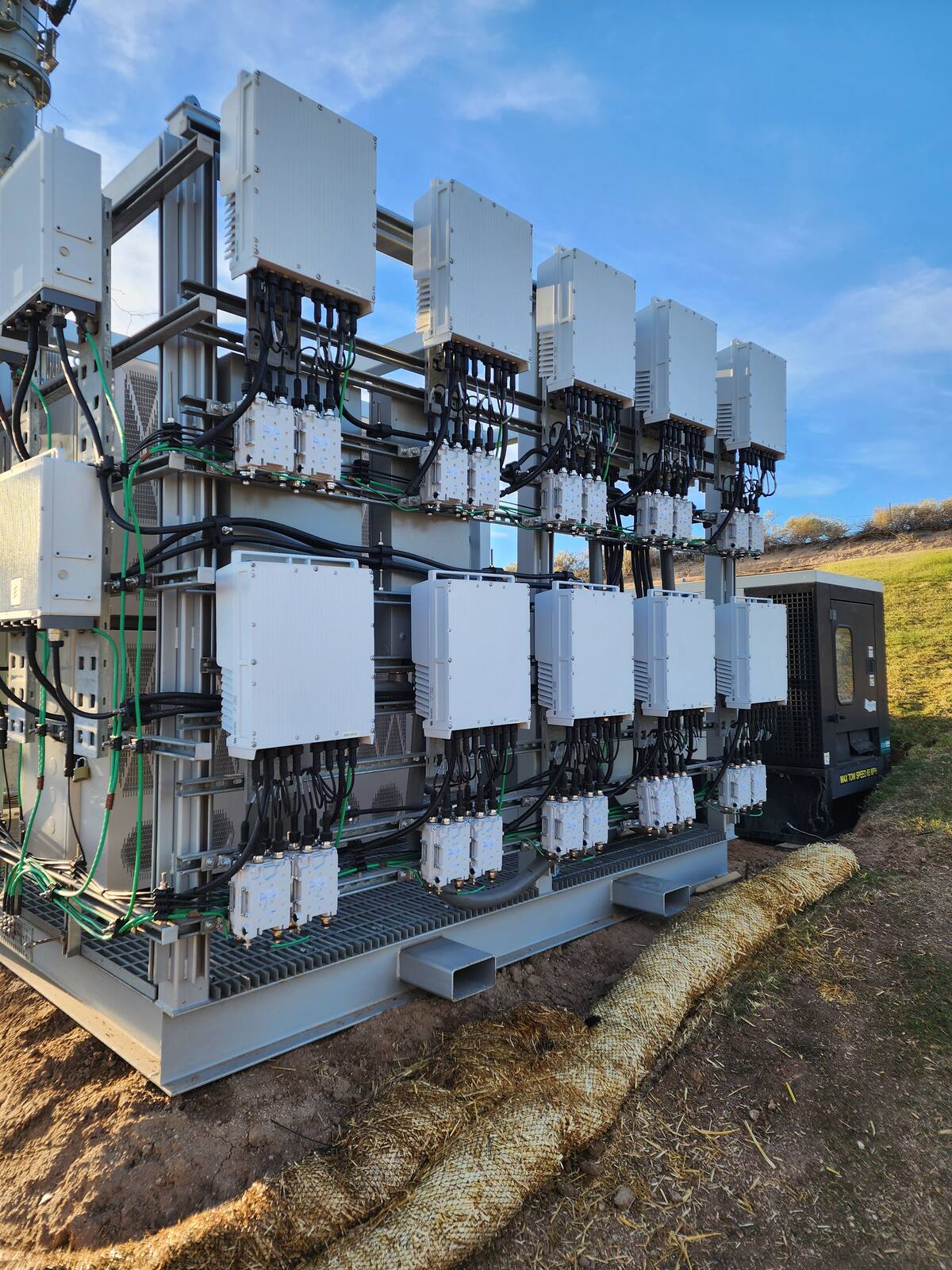 Radio and remote radio head skid with fiber and power cabling at a temporary site