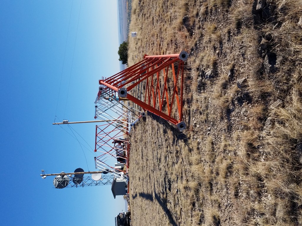 Painted tower sections staged on a ridge before erection